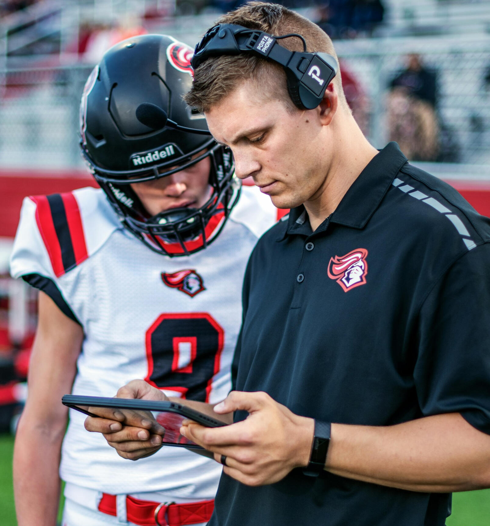 American football coach showing tactics on tablet to player — real-time learning and situational mindset training