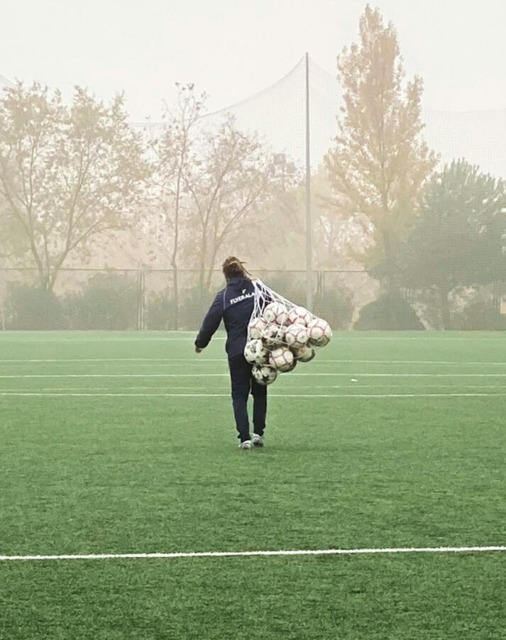 Football (soccer) coach carrying a ball bag — preparation, planning, and development environment