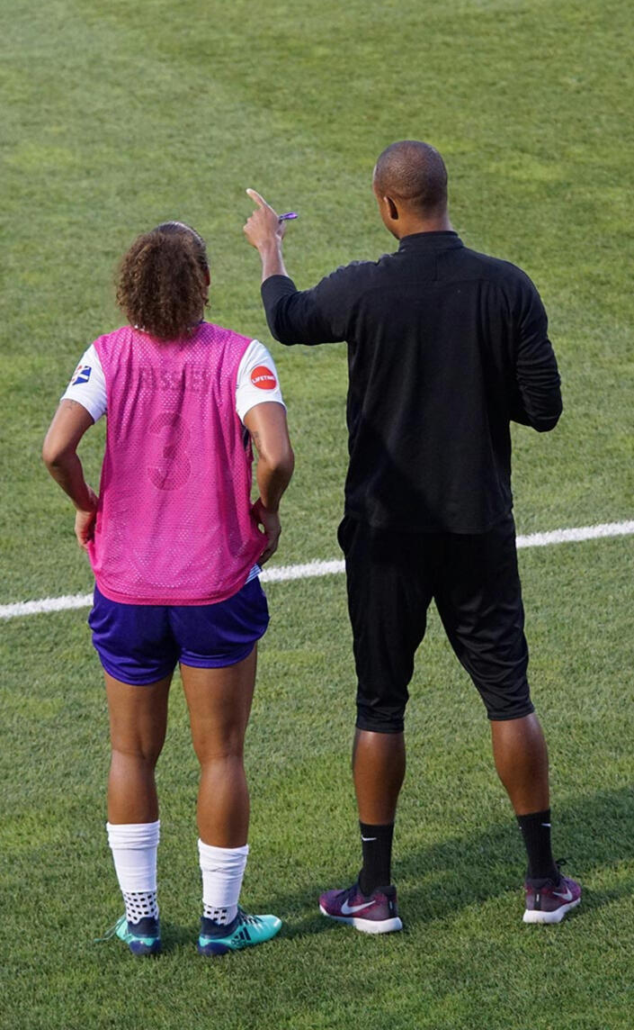 Football (soccer) coach giving final instructions to substitute — mental readiness before entering the game