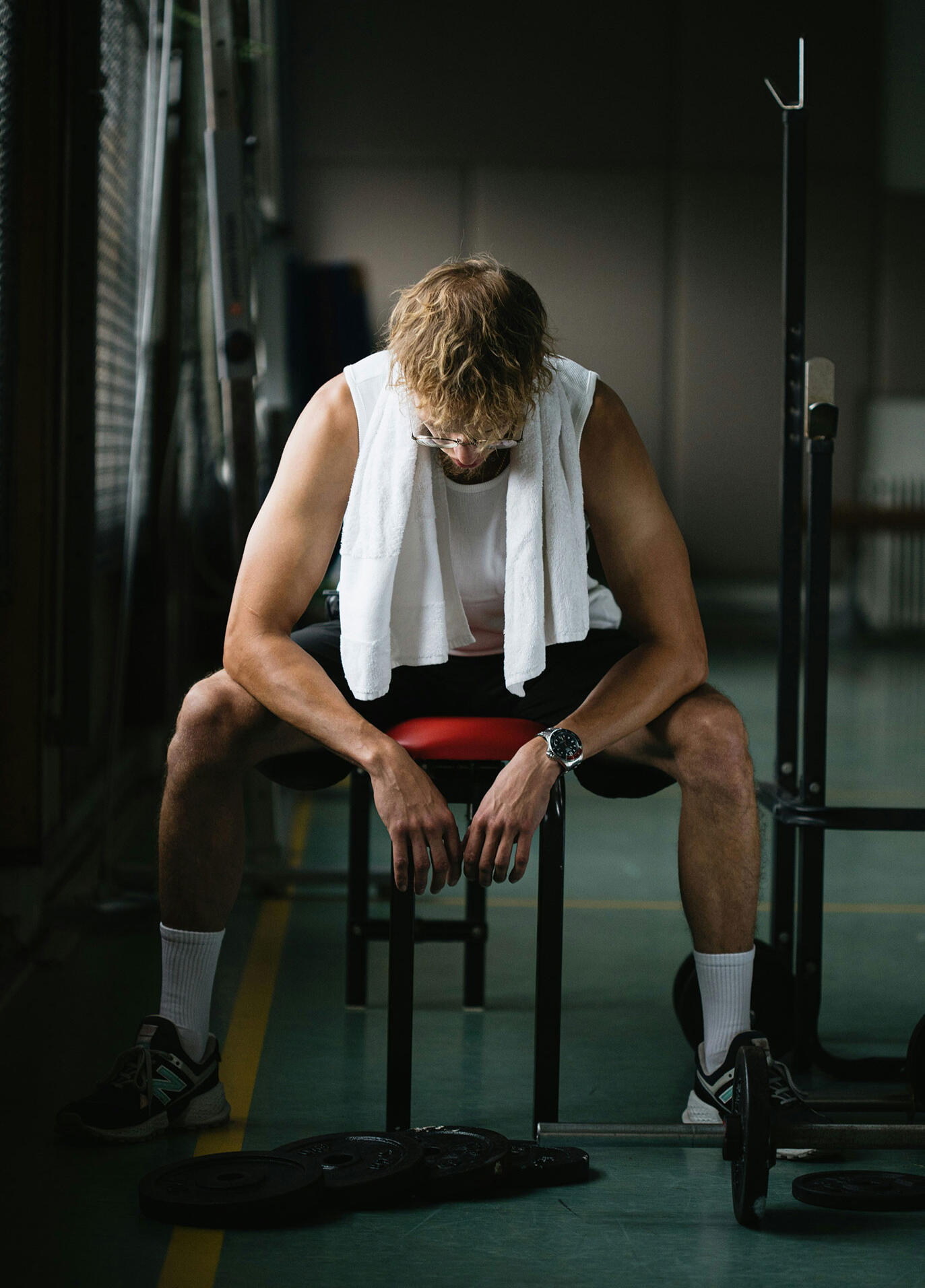 Athlete sitting in locker room, reflecting before or after competition — emotional moment tied to mindset