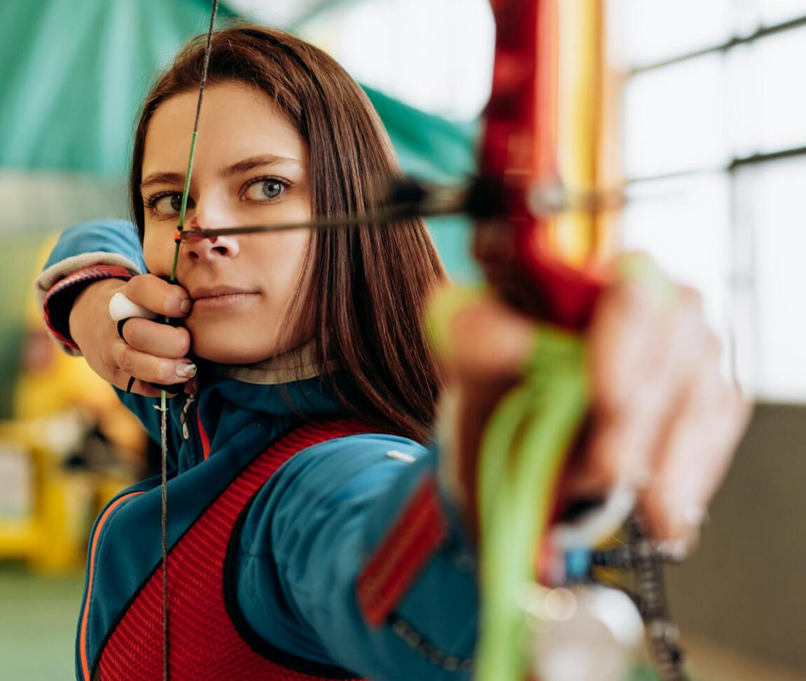 Focused archer aiming arrow — representing concentration, control, and high-performance mental training