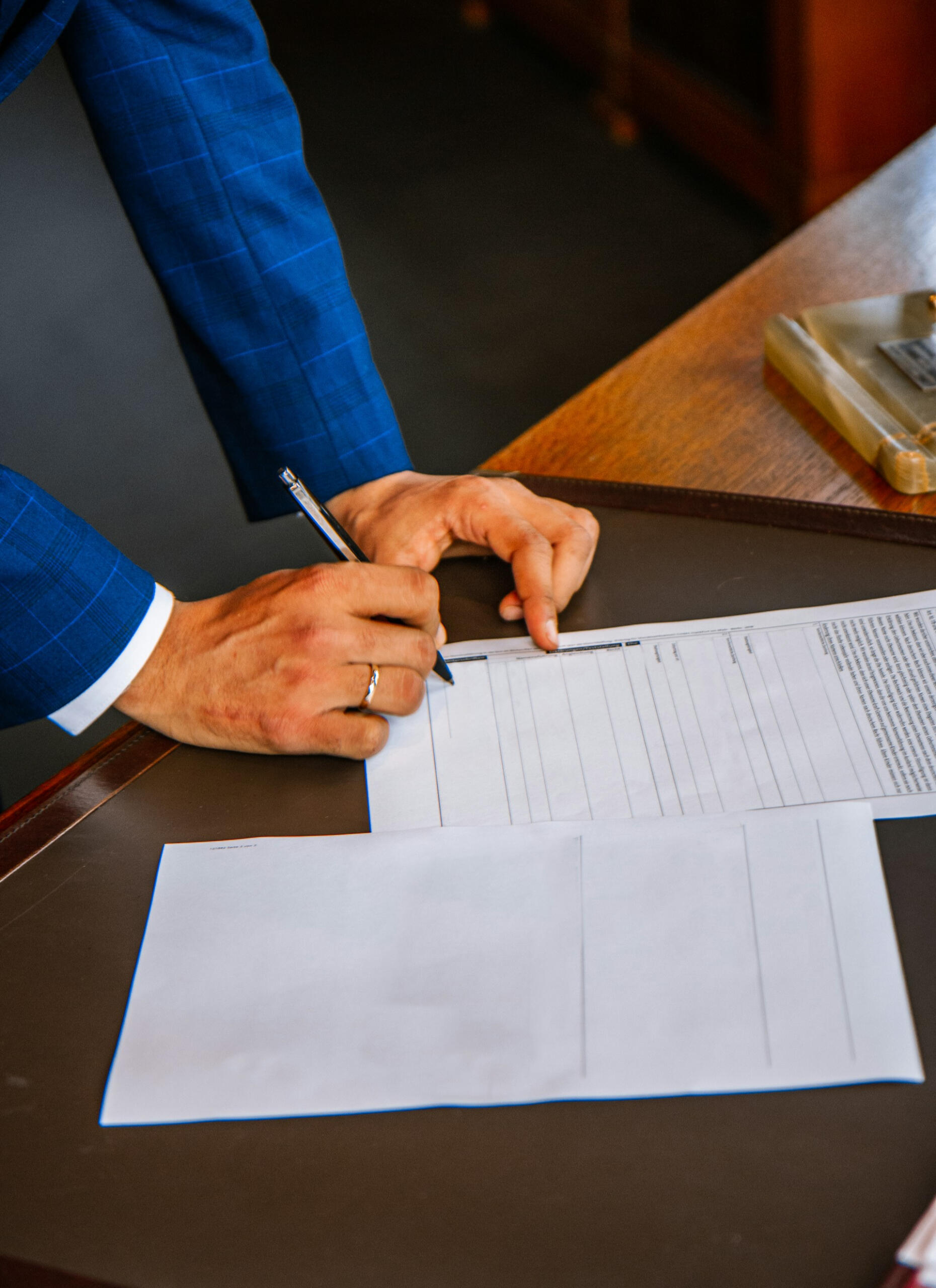 Close-up of person in suit signing contract — professional agreement, support system for young athletes