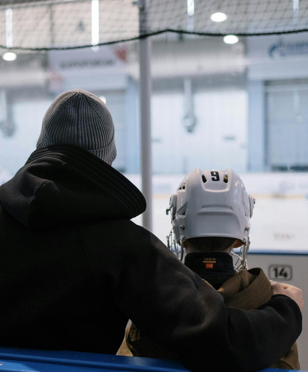 Father and son watching ice hockey — family support, long-term athlete development, and emotional roots